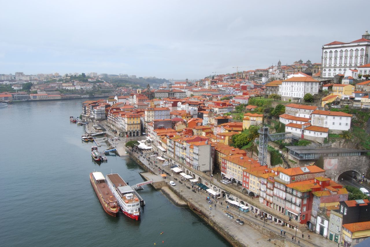 A stunning aerial view of Porto's waterfront with vibrant buildings and boats along the Douro River.
