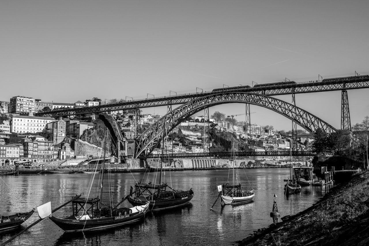 Black and white photo of Dom Luís I Bridge over Douro River in Porto, Portugal.